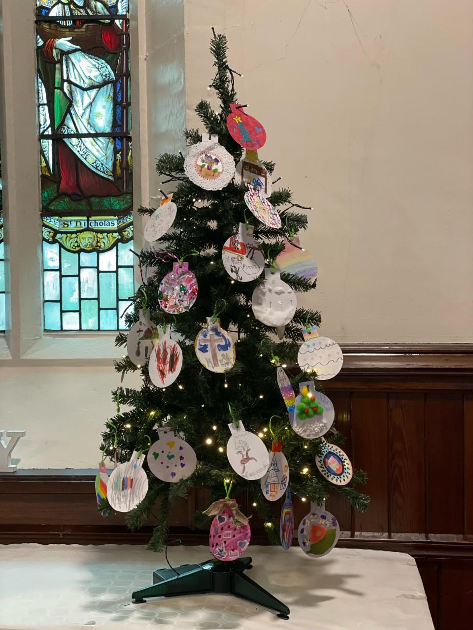 Christmas tree decorated with baubles made by the children at school